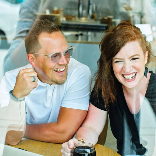 Shelly and Jason laughing together at a café table